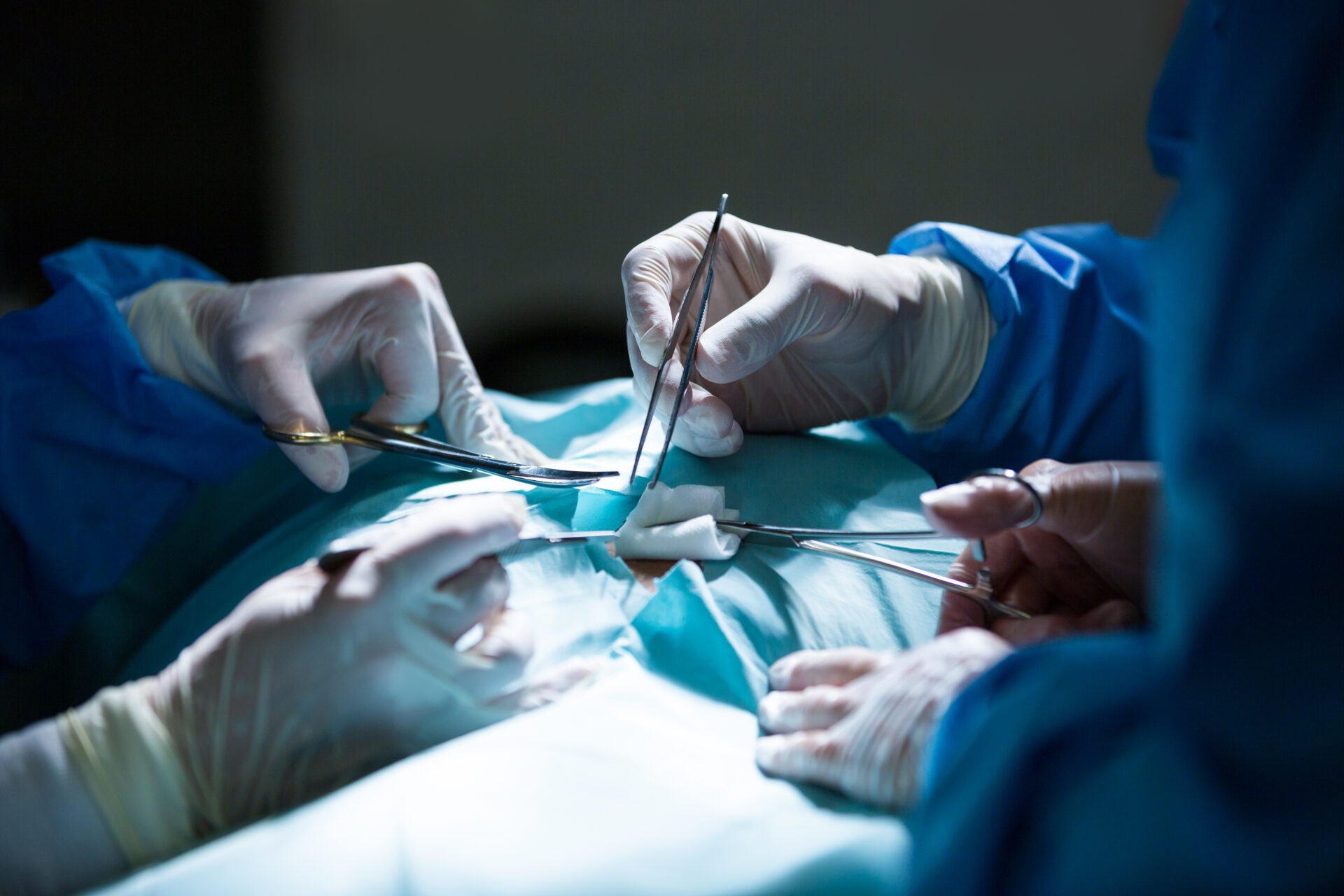 Surgeons performing operation in operation room Surgeons performing operation in operation room